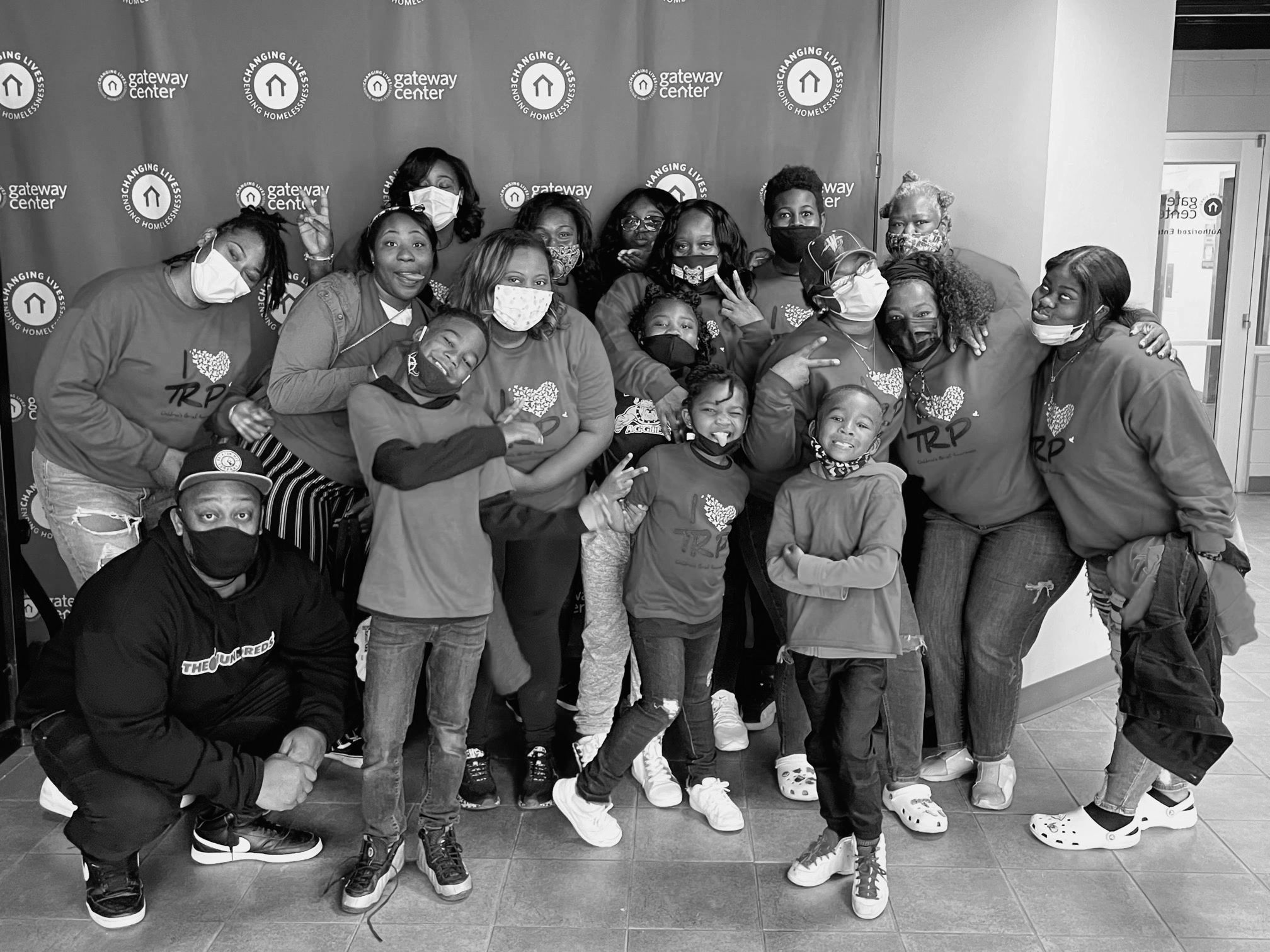 Group photo of diverse people wearing masks and matching shirts at Gateway Center.