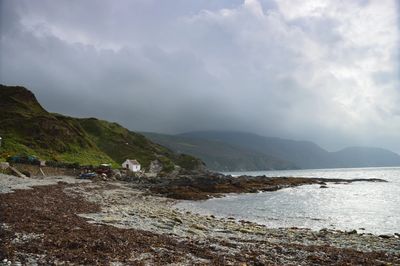 Niarbyl bay with mist and rain descending over the cliffs. A small fisherman's cottage is visible in