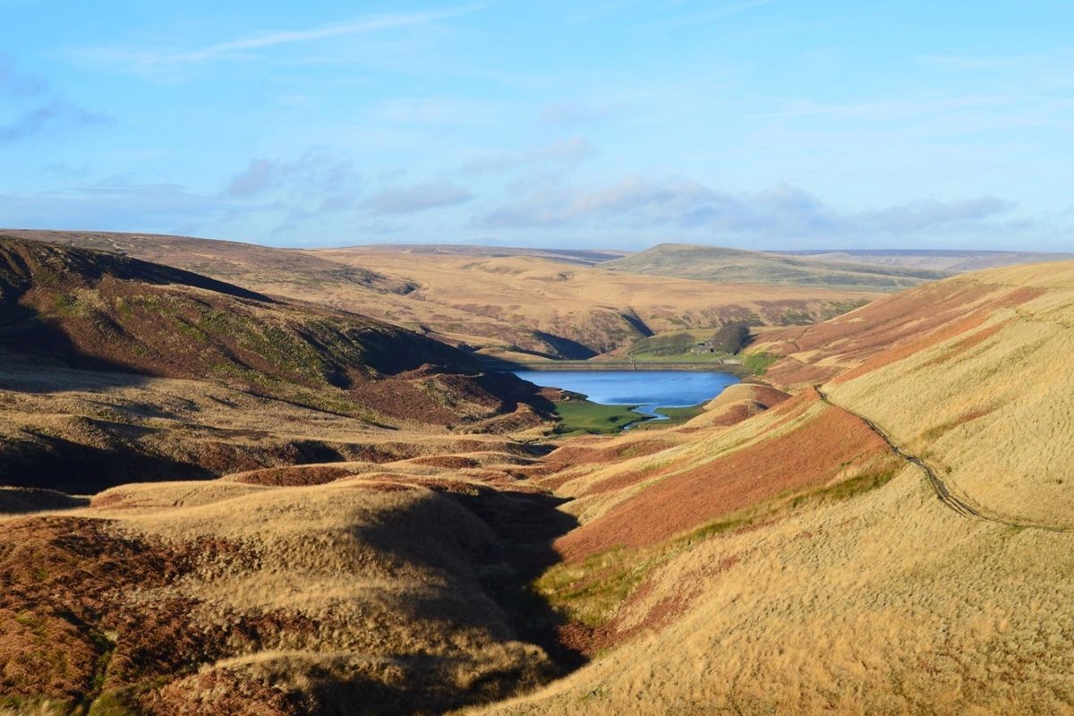 Autumn hills surrounding a reservoir with blue sky overhead
