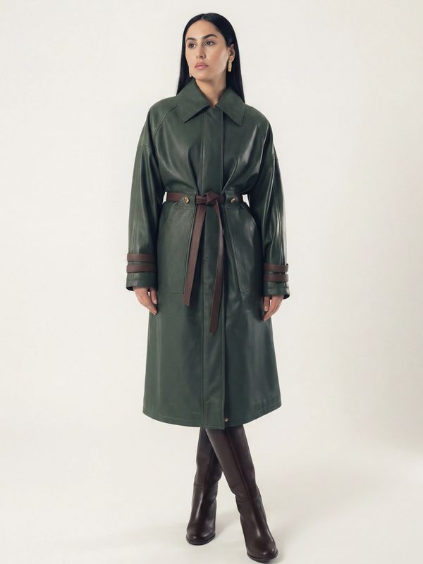 Woman wearing a green leather trench coat with brown belt and boots.