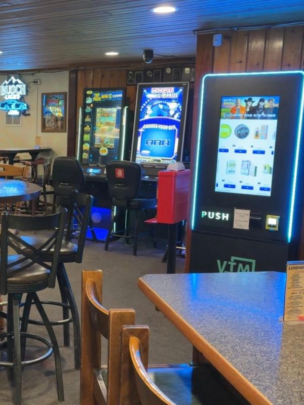 Empty bar area with gaming machines and seating.