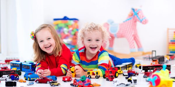 	“Young children engaged in imaginative play with toy vehicles.”