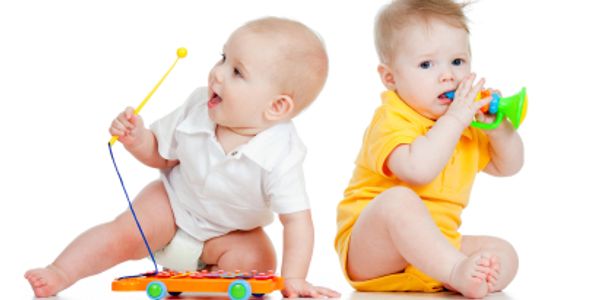“Toddlers enjoying a musical toy with buttons and sounds.”