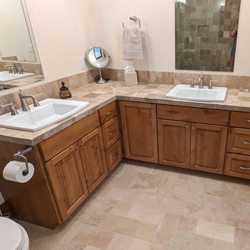 Modern bathroom with dual sinks and wooden cabinetry.