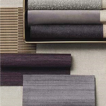Aesthetic fabric swatches in muted purple and grey tones beside a brass lamp by Bon Marche Interior Design Abu Dhabi