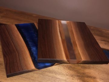 Black walnut cutting board with deep blue and clear pigmented epoxy