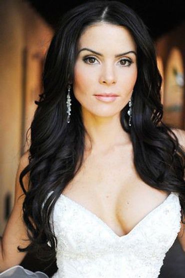 Woman with long dark hair and white dress.