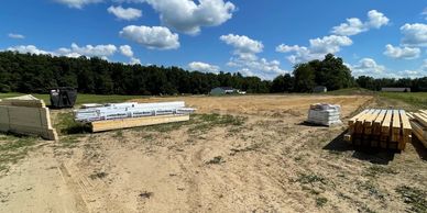 Post frame pole barn structure materials dropped off to build site. 