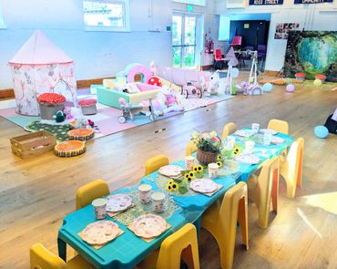 Colorful kids' party setup with table, chairs, and play area.