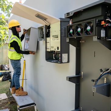 electrician mounting an electrical panel to a home 