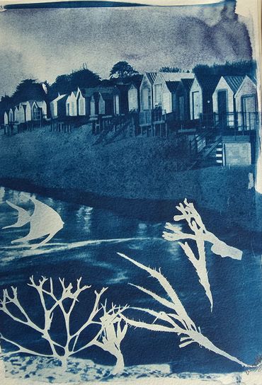 Blue-toned seaside scene with beach huts and coral silhouettes.