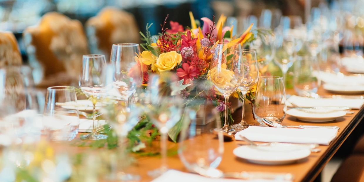 Elegant dining table set with flowers and glassware for a formal event.