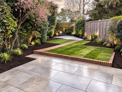 Modern landscaped garden with porcelain patio and striped lawn in Amasham