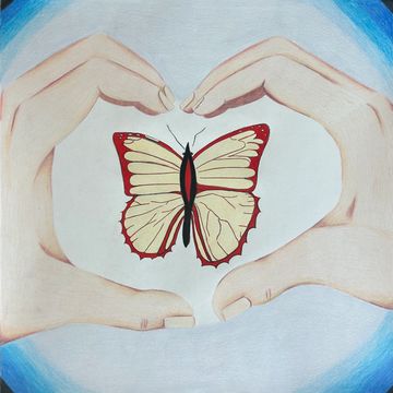 A cream and red butterfly encased by hands in the shape of a heart. 