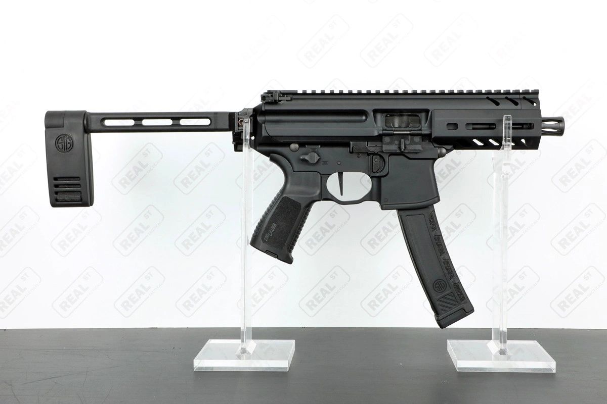 Black SIG Sauer submachine gun with a folding stock on display stands.