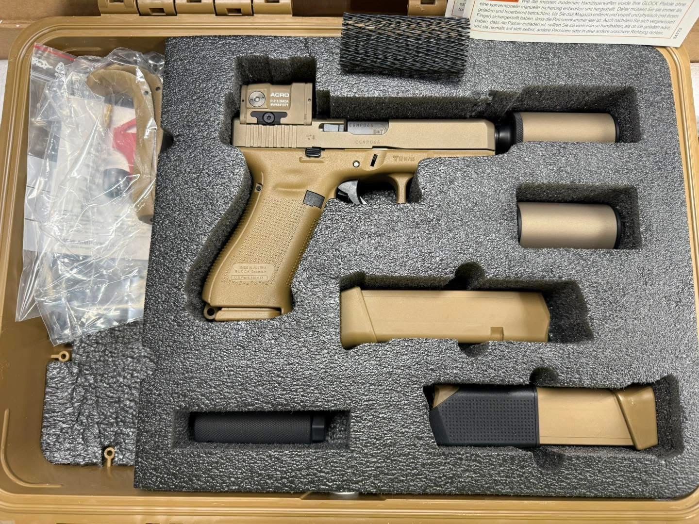 Tan Glock pistol with accessories in a foam-lined case.