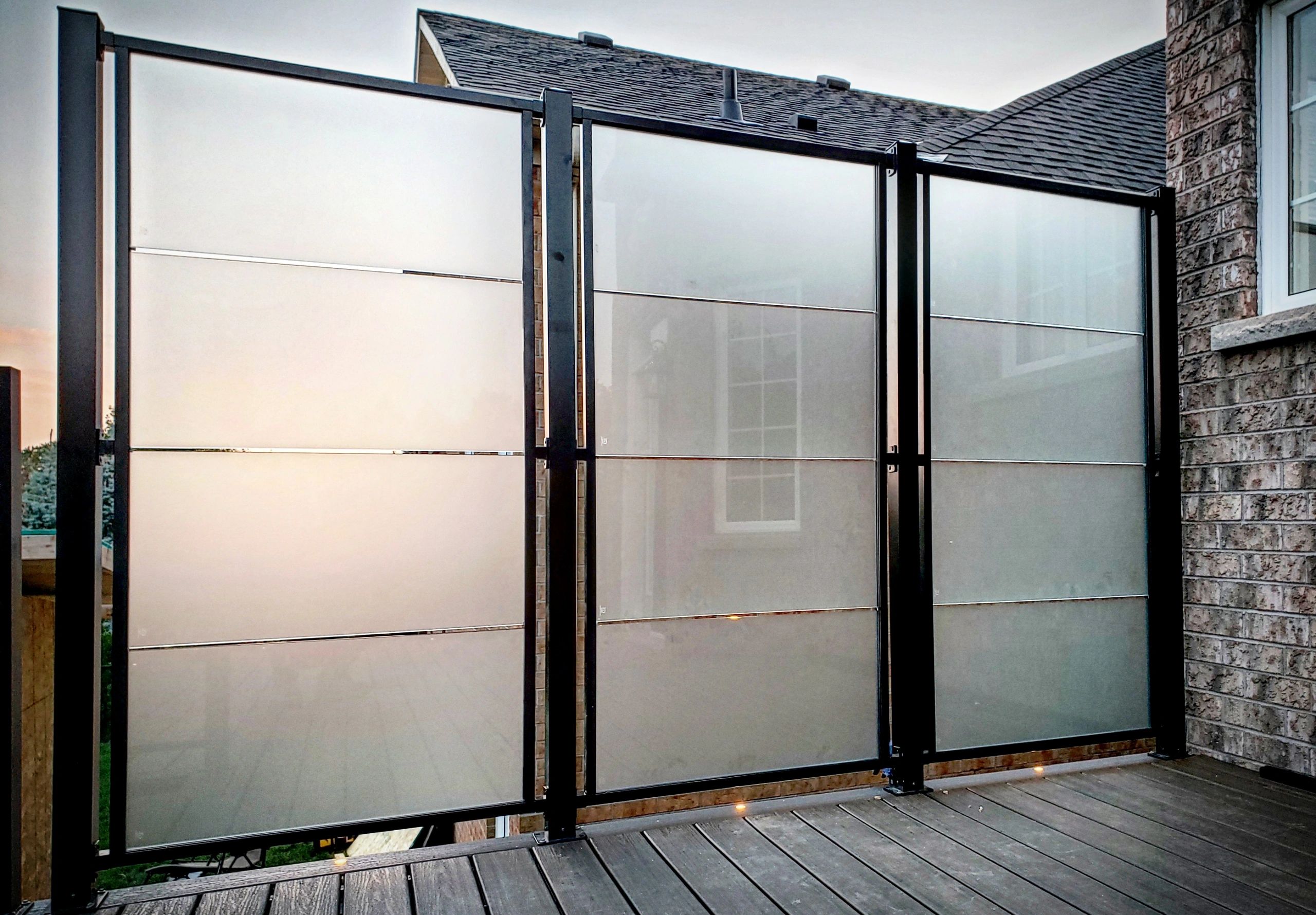 An  custom aluminum and glass privacy screen in Oakville, Ontario on a Trex Company composite deck.
