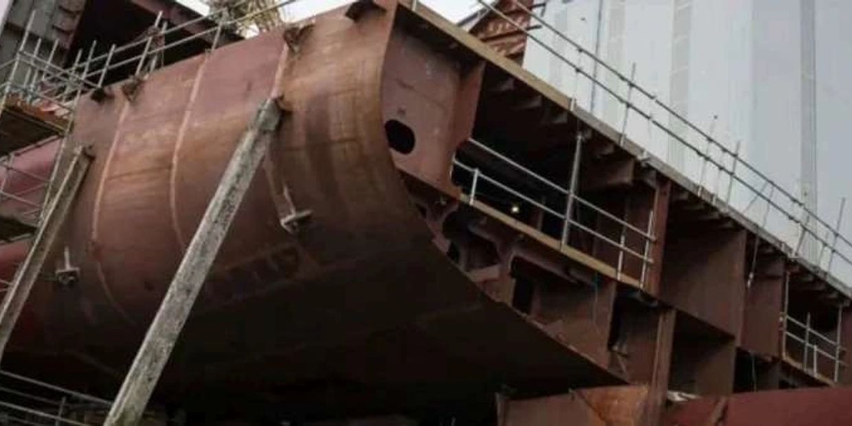 Close-up of a ship's hull under construction with scaffolding around it.
