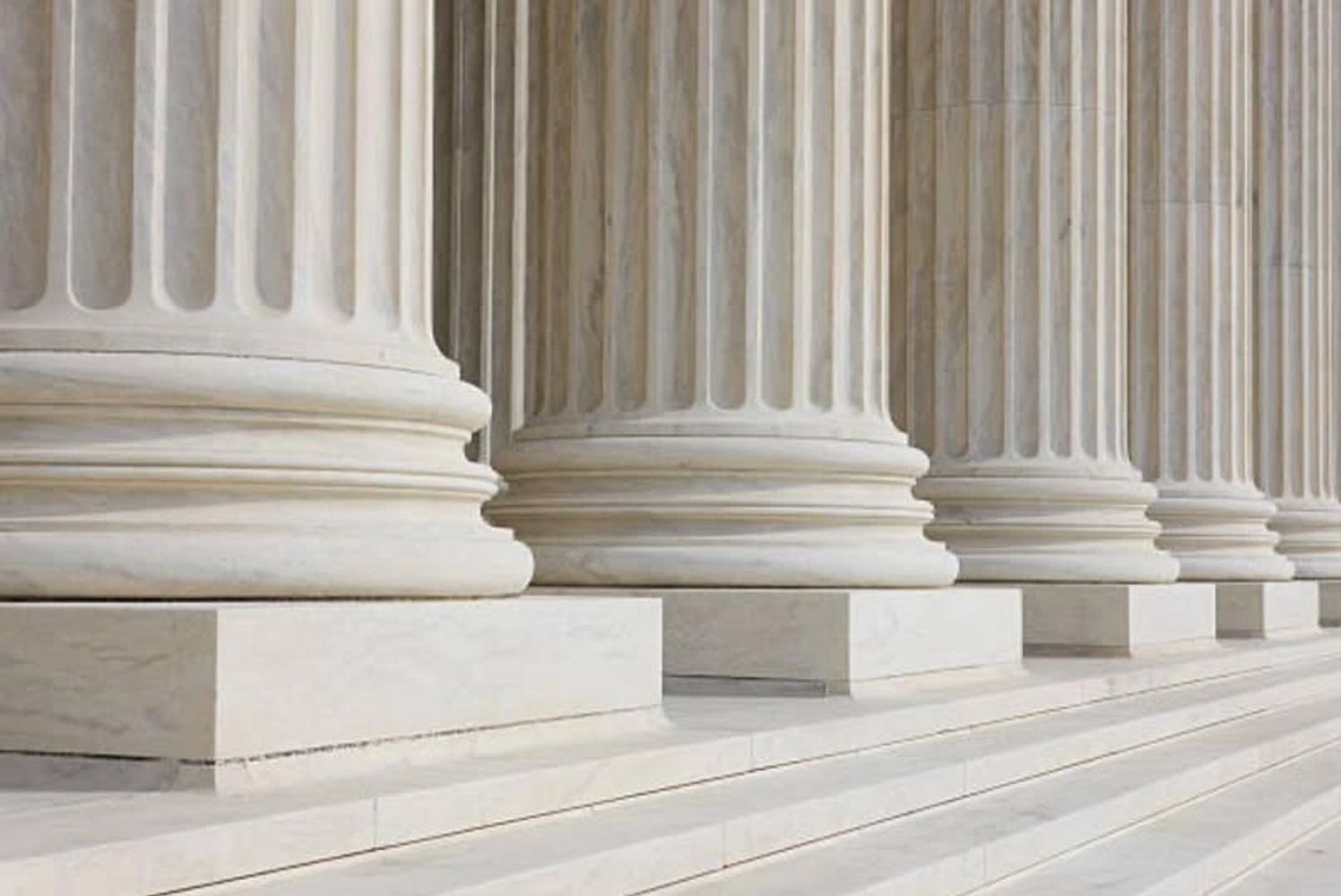 Close-up of large classical columns on a marble building.