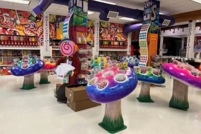 A colorful candy store with mushroom-shaped candy displays and vibrant decor.