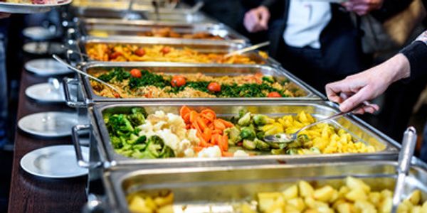 Several Buffet trays filled with a variety of food items. 