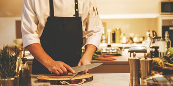 A chef Sharpening his knife.  In a kitchen