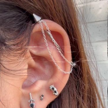 Curated ear piercing with chain by Pamela Spector