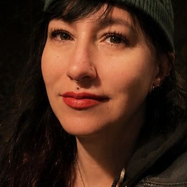 Close-up of a woman with piercings and a knit hat.