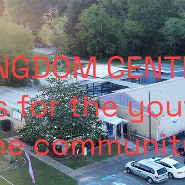 Building and parking lot with cars showing the Kingdom Youth Center in Louisiana.