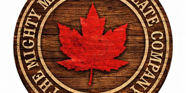 Logo of The Mighty Maple Syrup Chocolate Company with a red maple leaf on wood.
