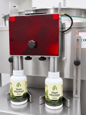 Machine filling Siam Moringa bottles automatically.