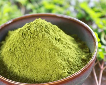 A bowl of green powder, likely matcha or henna.