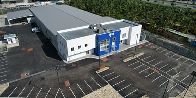 Modern industrial building with TPM signage and empty parking lot.