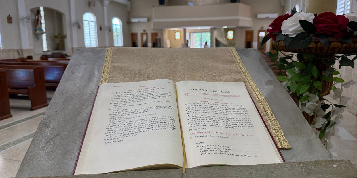 Biblia abierta sobre un atril en una iglesia.