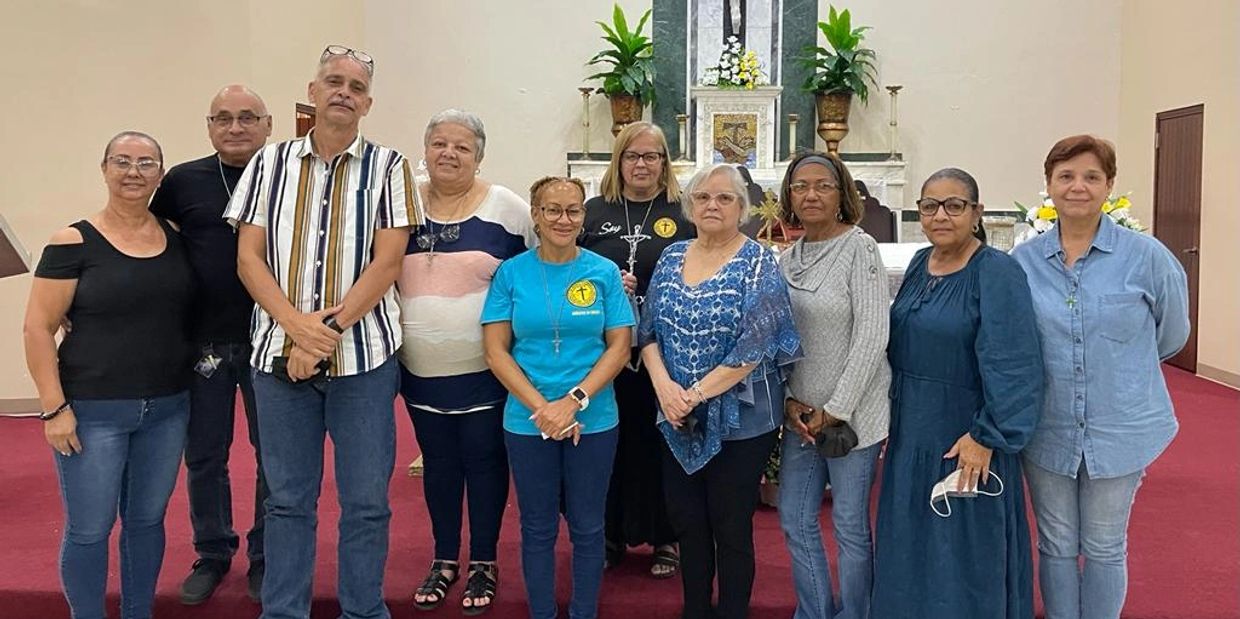 Group of people posing inside a church, standing in front of the altar.