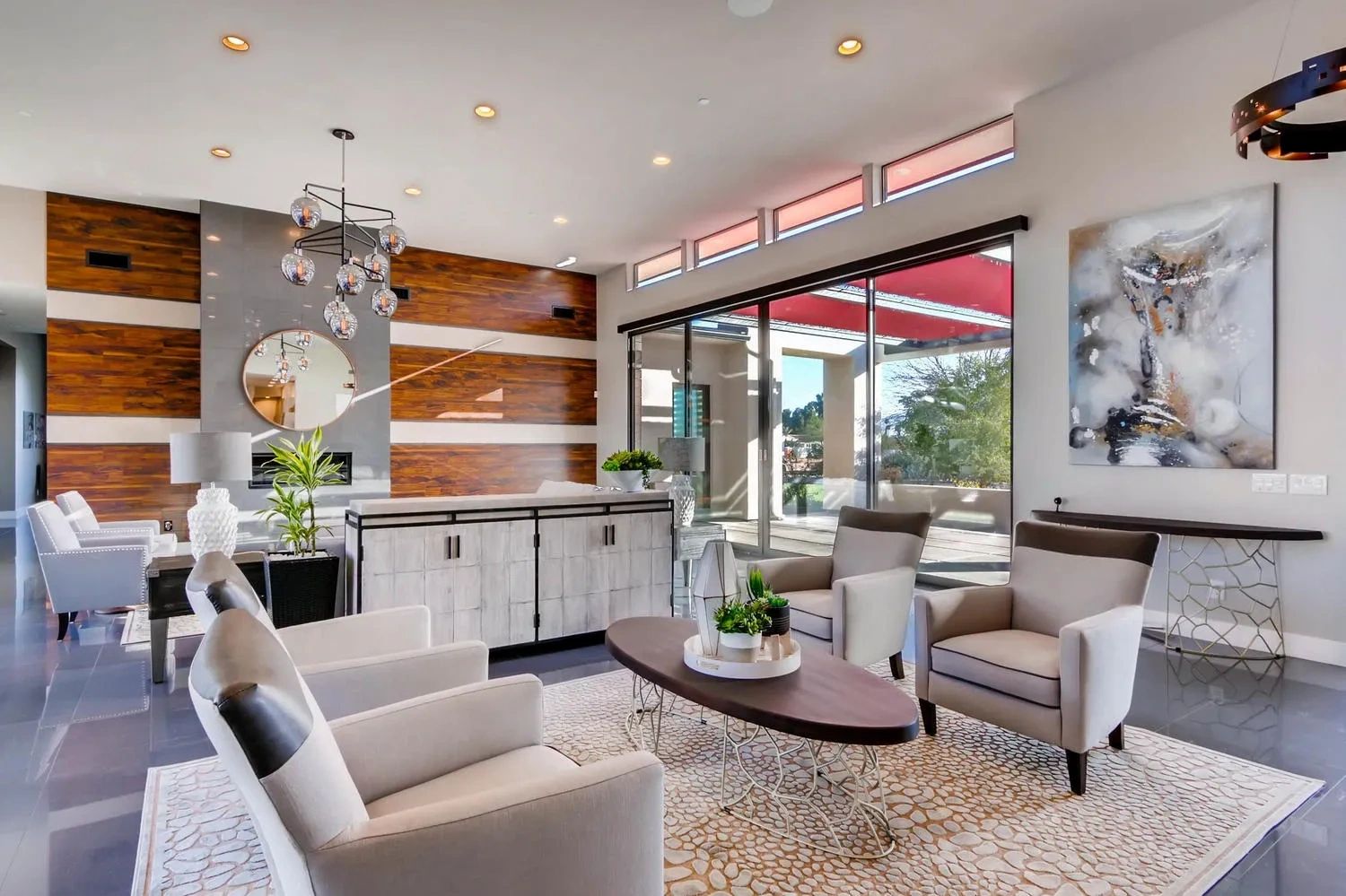 Modern living room with neutral tones and large windows.