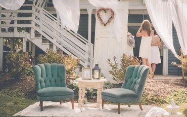 Sitting area composed of 2 chairs, rug, table, door, mirror or wreath, lantern and frame. 