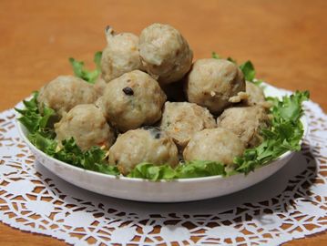 Plate of meatballs garnished with lettuce on a lace doily.