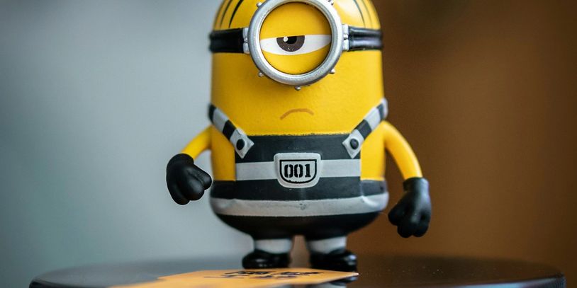 A serious one-eyed Minion figurine in prison attire.