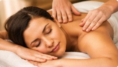 Woman enjoying a relaxing back massage with eyes closed.