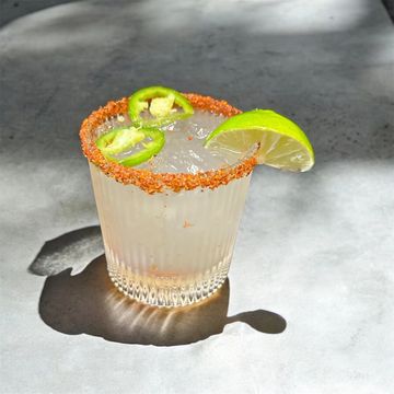 A lime and jalapeño garnished cocktail with chili salt rim.