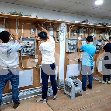 四人正在安装或维修电气系统。