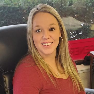 Staff member and customer service representative Crystyn Pollard sitting at her desk inside the Sage Creek Insurance Services office.