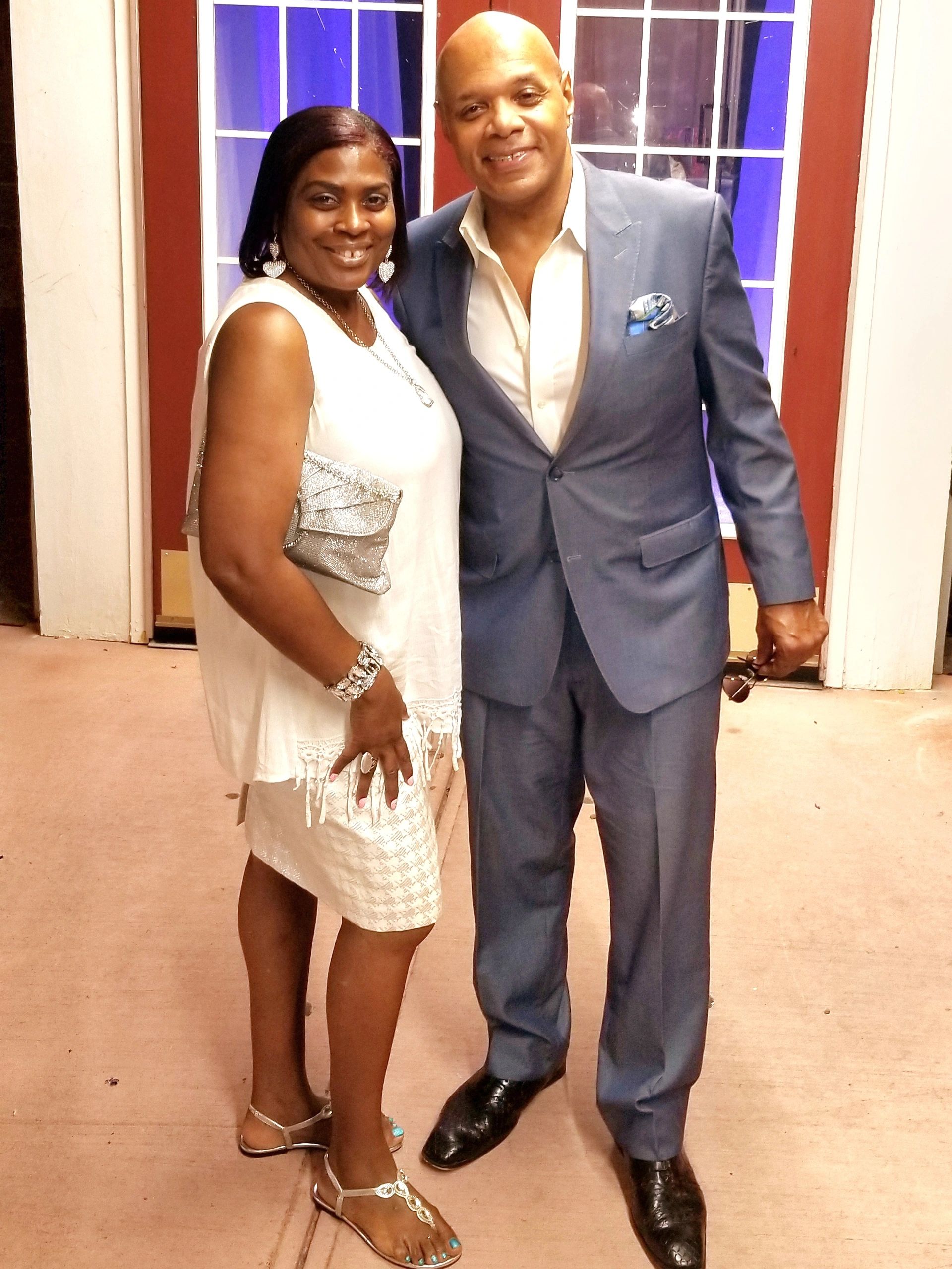 A smiling couple dressed elegantly posing together.