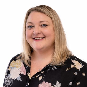 A picture of Lucy the founder and Director, Blonde shoulder length hair and wearing a flowered shirt