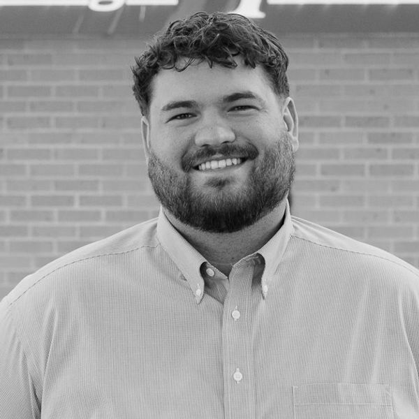 Photo of Watkins Carter partner, Carter Ballenger smiling in front of commercial building.