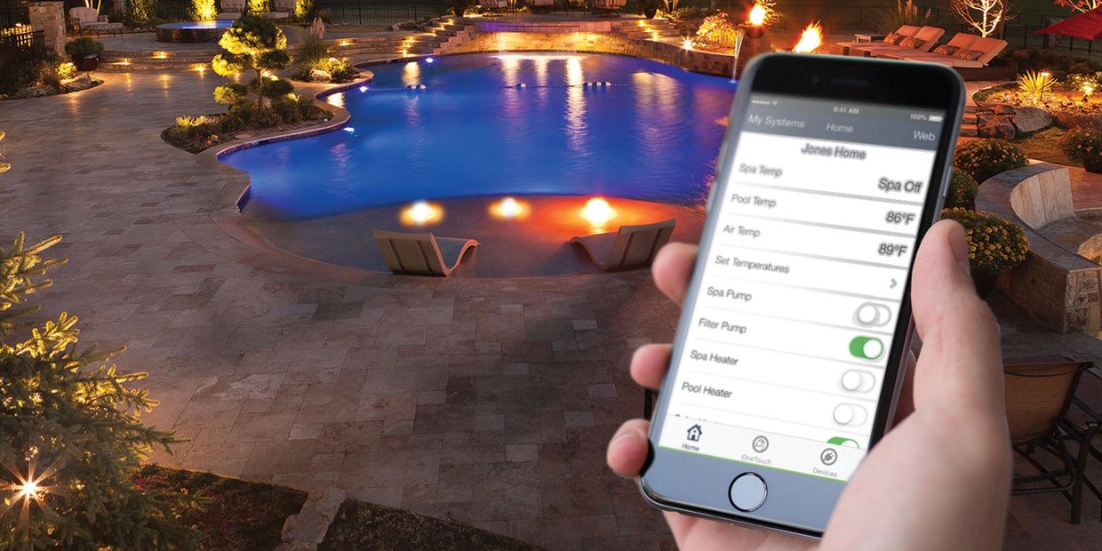 A hand holding a phone controlling a pool at night.