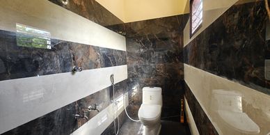Modern bathroom with striped black and white tile walls and a white toilet.