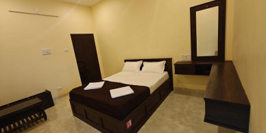 Cozy bedroom with a double bed and wooden furniture.