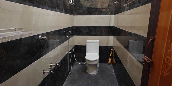 Modern bathroom with black and beige striped walls and a white toilet.